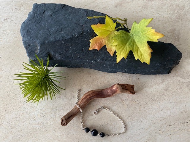 Bracelet en argent monté avec 3 perles de tourmaline noires séparées par 2 petites perles en argent 